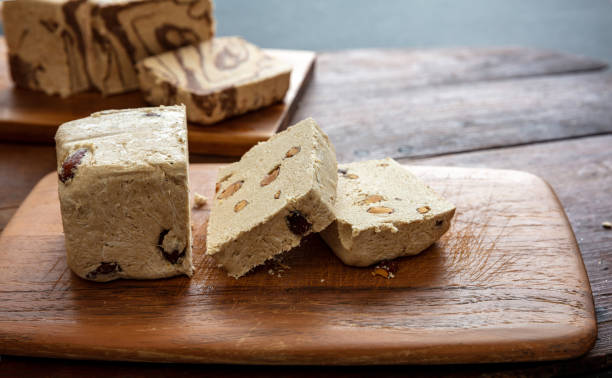 istock Halva almond nuts slices on wooden table background 1308772484