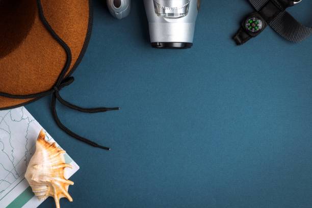 istock Cowboy hat, camera, geographic map, compass and seashell on a blue background. 1308777794