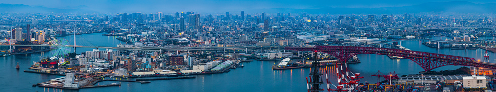 Aerial panoramic photograph over the neon lit cityscape of Osaka, Japan.