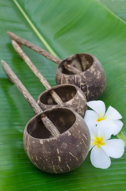 Old thai style coconutshell ladles on green banana leaf