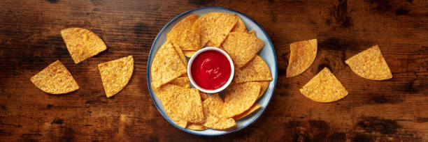 istock Nachos panorama with a tomato salsa, top shot 1308783257