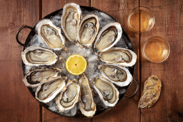 istock Oysters and wine. A dozen of fresh oysters with lemon 1308783391