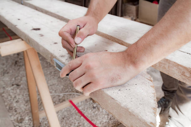 Male carpenter working with wood material in a garage.