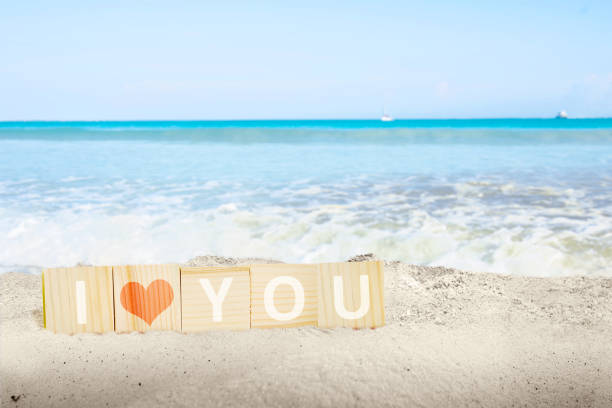 Wooden cube with I Loves You message with a beach background. Valentines day