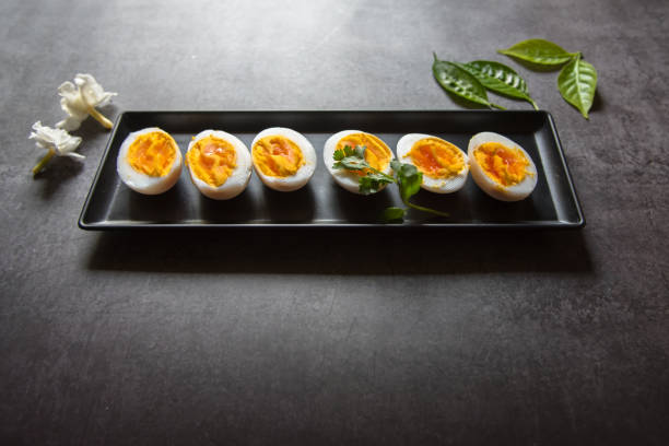 istock Slices of boiled eggs arranged on a black tray 1308791846