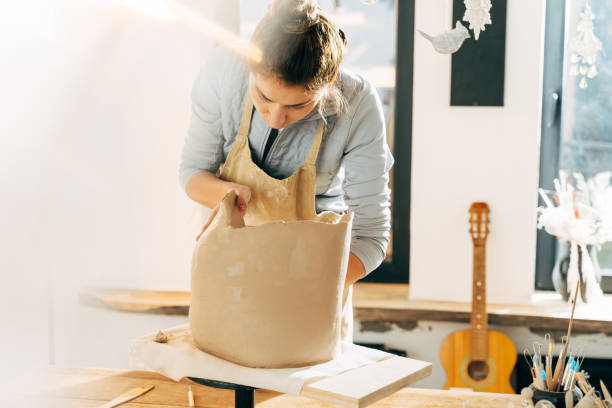 istock Happy potter making a ceramic pot on the pottery table 1308797940