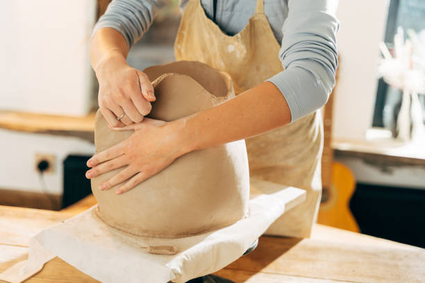 istock Unrecognized artist sculpting from wet clay in studio 1308797945