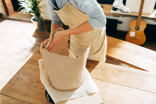istock Happy potter making a ceramic pot on the pottery table 1308797952