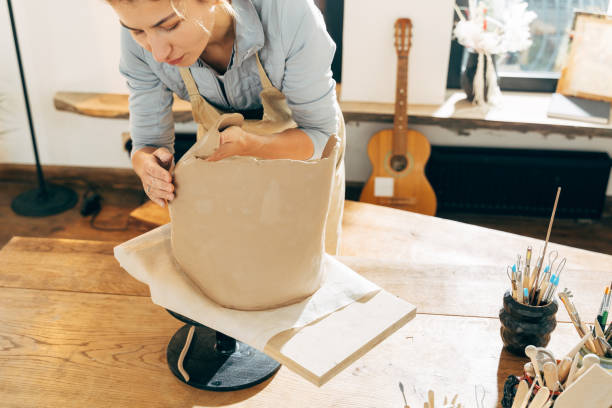 istock Master putting freshmade clay jar on wooden board in workshop 1308797985