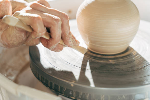 istock Potter modeling ceramic pot from clay on a potter's wheel 1308798014