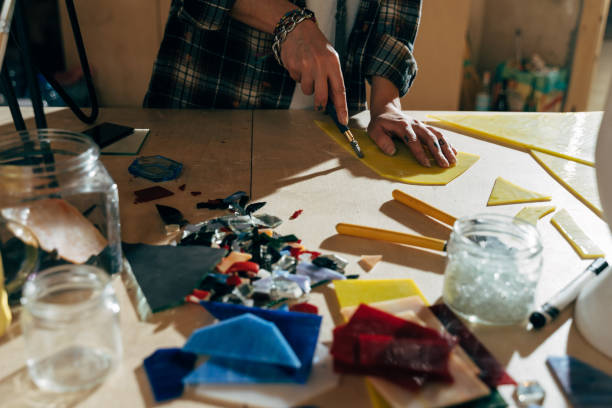 istock Designer cutting glass with special tool while preparing pieces for mosaic 1308798091