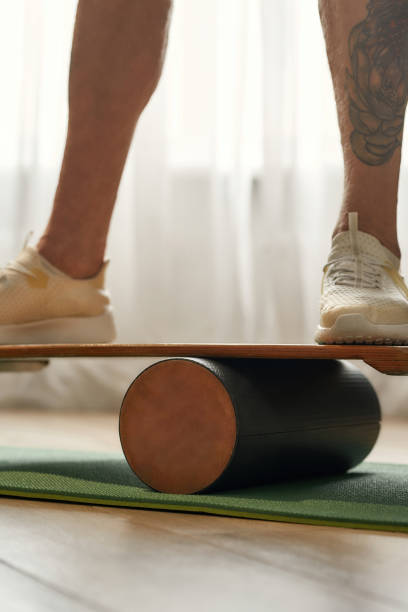 istock Man in sneakers standing on balance board 1308798627