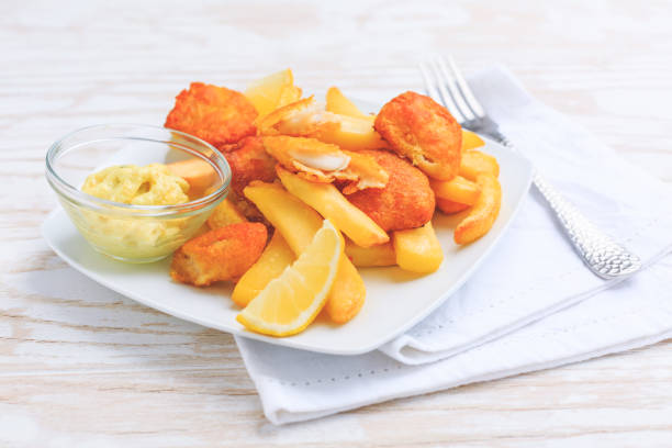 istock Fish and chips with dip and lemon on white plate 1308798810