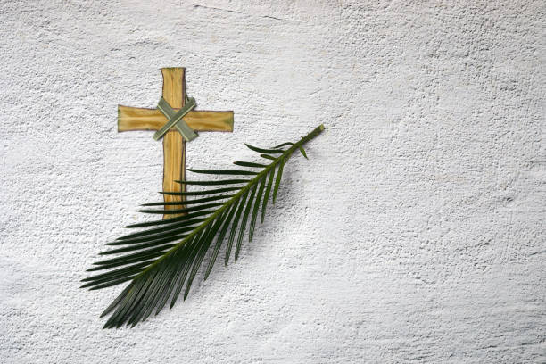 istock Palm sunday background. Cross and palm on grey background. 1308800647