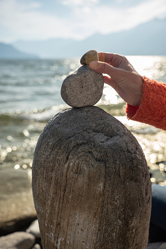 Detail of person stacking rocks by the lake, shot in Ticino Canton, Switzerland.
People life balance concept