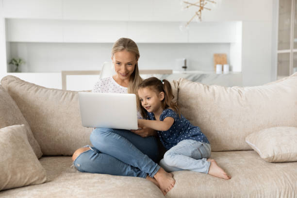 istock Happy young mother and small daughter use laptop 1308806392