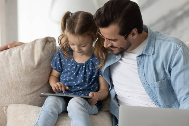 istock Caring dad and small daughter use tablet 1308806398