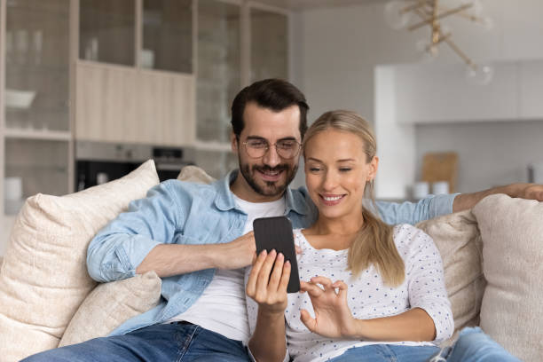 istock Happy couple sue cellphone talk on webcam call 1308806457