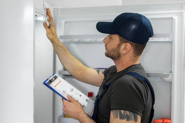 Young technician checking refrigerator Young technician checking refrigerator fridge fix stock pictures, royalty-free photos & images