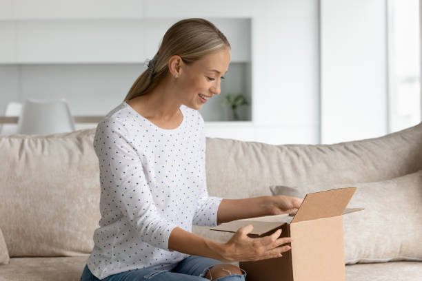 istock Excited Caucasian woman unpack box with internet order 1308806599