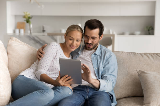 istock Happy couple relax at home using tablet 1308806601