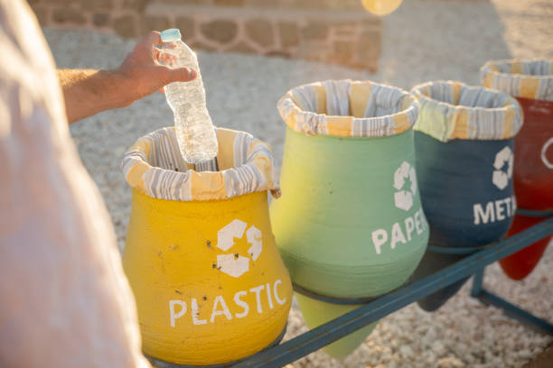 istock Close up on person hand throwing plastic water bottle into recycling bin 1308806845