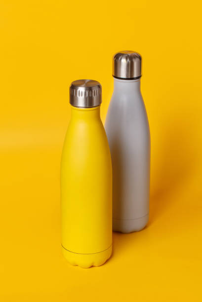 istock Yellow and grey reusable steel bottles on yellow background 1308810269