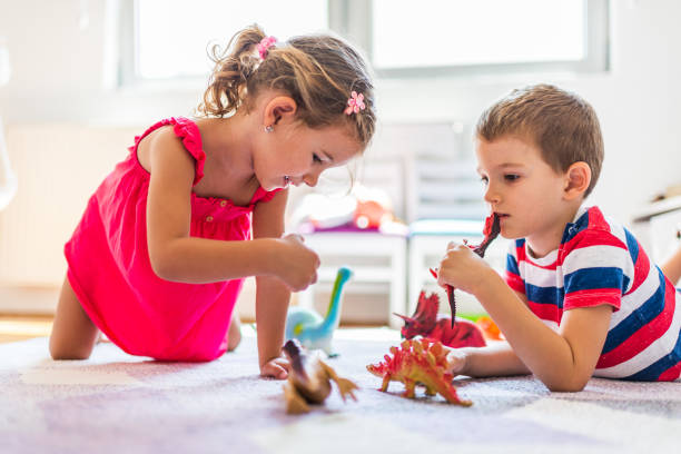 istock Children playing with toy dinosaurs 1308810645