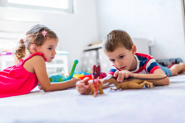 istock Children playing with toy dinosaurs 1308810687