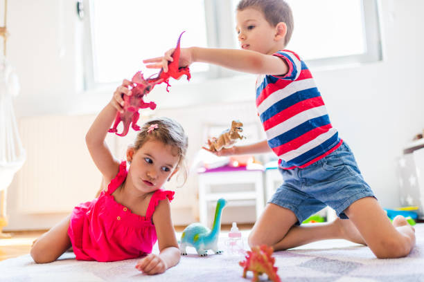Children playing with toy dinosaurs