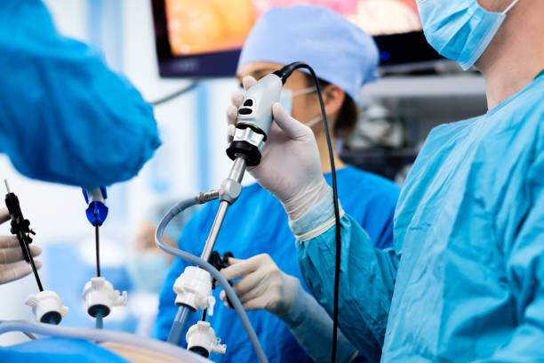 Selective focus on the hand of a surgeon wearing a sterile latex glove holding a special medical instrument during laparoscopic surgery. Selective focus on the hand of a surgeon wearing a sterile latex glove holding a special medical instrument during laparoscopic surgery. Minimally invasive surgical treatment of proctological diseases colon stock pictures, royalty-free photos & images
