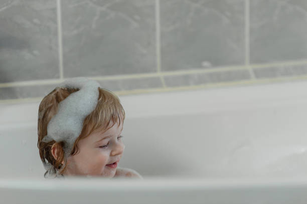 istock little smiling child sits in a large bubble bath. View from above. Flatley 1308817266