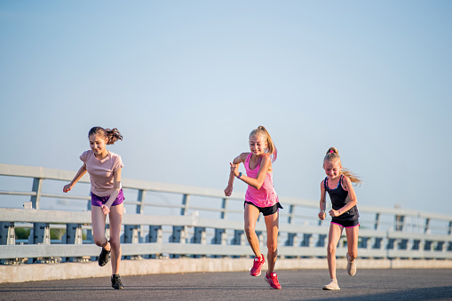 Three girls jogging on a sunny summer evening