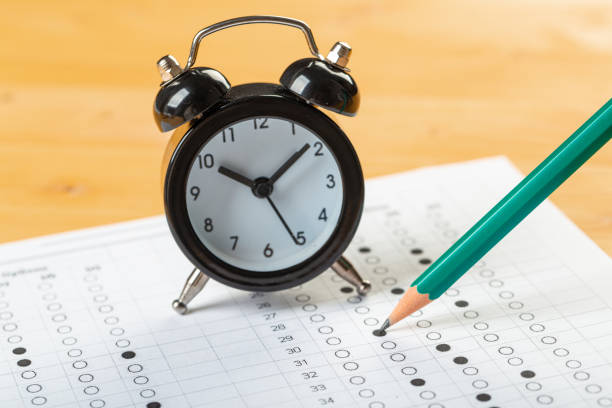 istock answer sheet, test in exercise and passing examination paper computer sheet with pencil alarm clock and pencil for education concept 1308820048