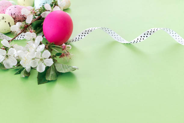 istock Beautiful Easter card with colorful eggs and cherry branches on paper beige background. 1308822339