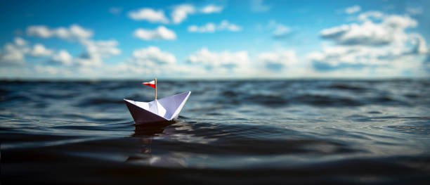 istock Paper Boat sailing on big Waves 1308824027