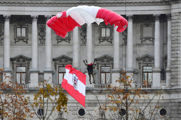 Parachute demonstration of the Austrian army A Parachutists of the armed forces is landing on the Heldenplatz in Vienna in front of the Hofburg palace fallschirm stock pictures, royalty-free photos & images
