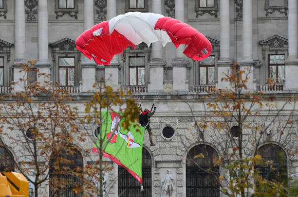 Parachute demonstration of the Austrian army A Parachutists of the armed forces is landing on the Heldenplatz in Vienna in front of the Hofburg palace fallschirm stock pictures, royalty-free photos & images