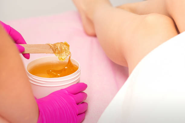 istock Cosmetologists waxing the female legs 1308825586