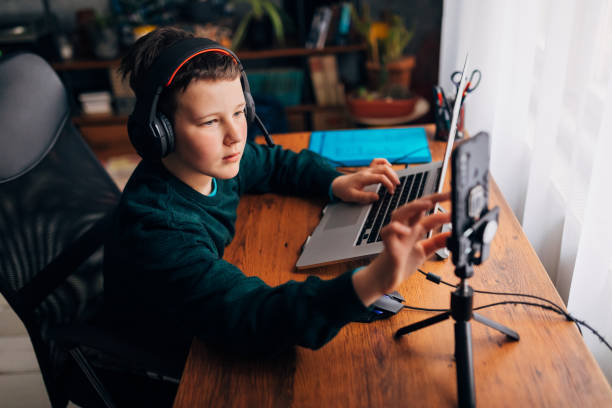 istock Ten year old video game vlogger, turning on camera on mobile phone, preparing everything for live streaming 1308825879