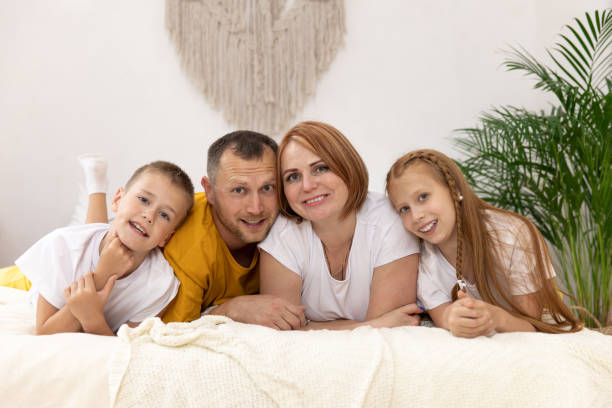 istock Cheerful family having fun together lying on a bed 1308826721