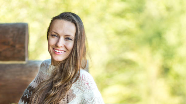 istock Positive nice young woman smiling while standing on a wooden terrace 1308827902