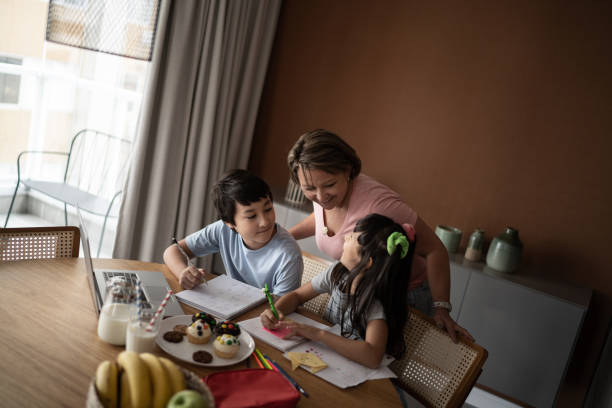 istock Mother helping children with homework 1308829977