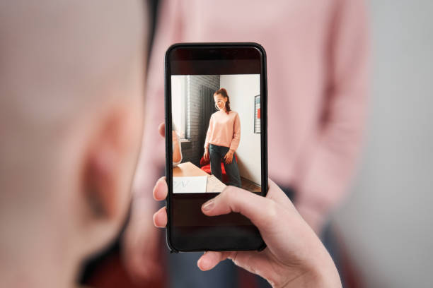 istock Girl shooting her girlfriend at the smartphone while she telling something 1308830445