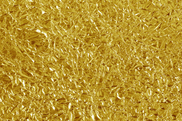 istock Gold foil leaf shiny texture, abstract yellow wrapping paper for background and design art work. 1308830797