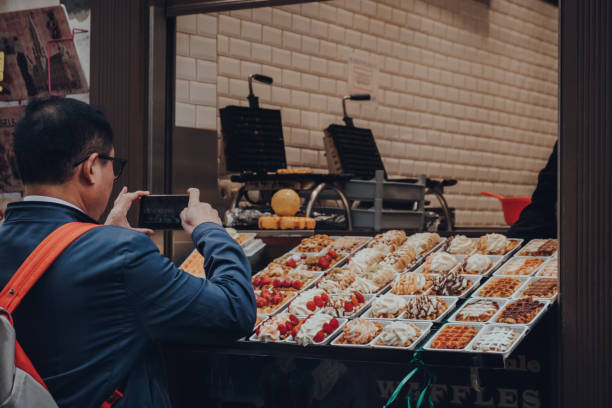 verschiedene traditionelle belgische waffeln mit verschiedenen toppings zum verkauf als geschäft in brüssel, belgien. - brussels waffle belgian waffle people stock-fotos und bilder