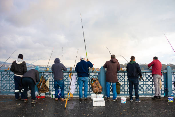 fischer auf der galata-brücke - fischer männlich stock-fotos und bilder