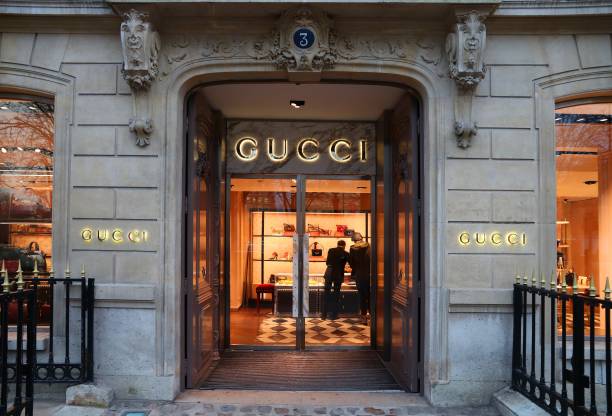 Gucci store in Paris People shop at Gucci fashion store in Avenue Montaigne Paris, France. Avenue Montaigne is one of most upscale fashion shopping streets in Europe. designer clothing photos stock pictures, royalty-free photos & images