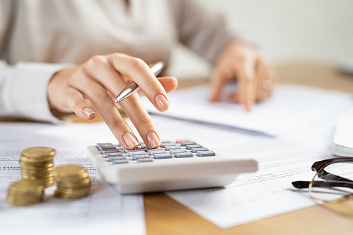 Mujer de negocios usando calculadora para administrar finanzas photo