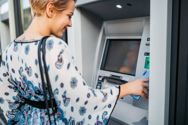 istock Withdrawing money at the ATM with phone 1308845185
